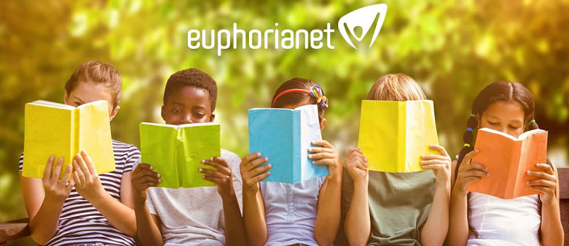 Grupo de cinco niños concentrados leyendo un cuaderno